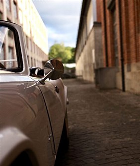 Close-up of a chrome mirror on an old white car