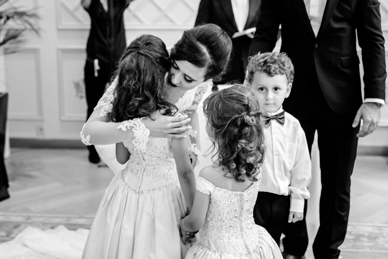 Etreinte de la mariée avec des enfants, nombreux à la cérémonie