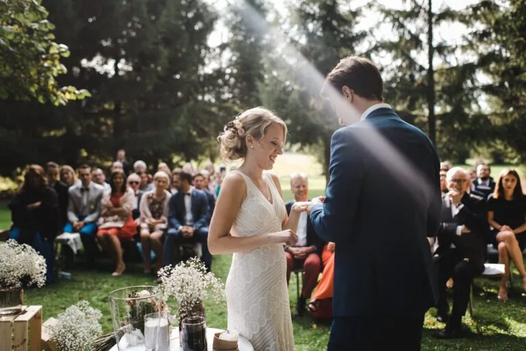 Une mariée souriante face à son futur époux lors d'une cérémonie