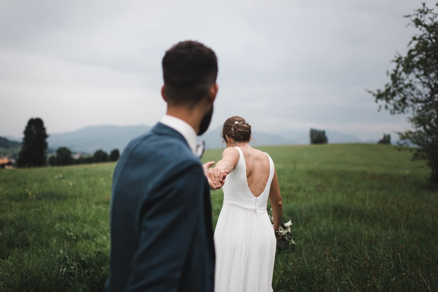 Les mariés se baladent dans les pâturages de la verte Gruyère pour un shooting de couple