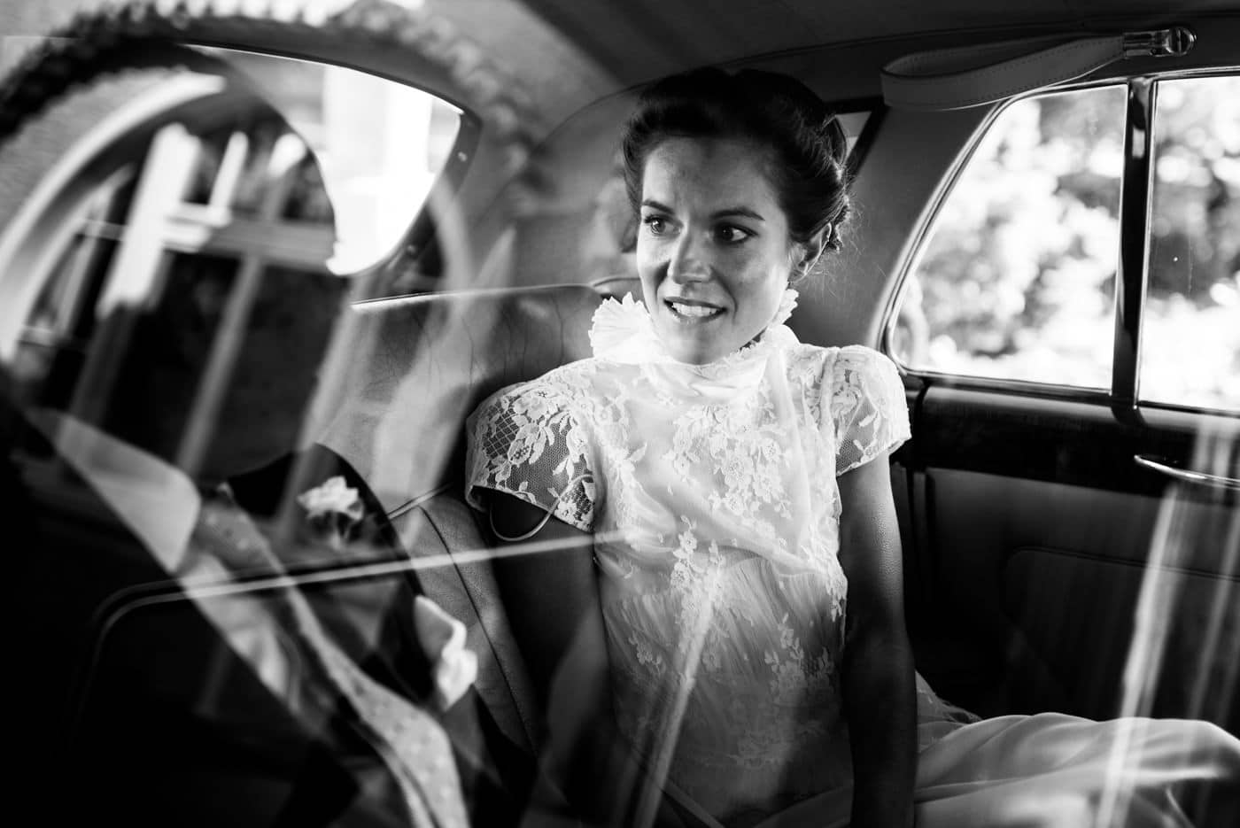 Les mariés sont complices dans la voiture oldtimer qui les amène à la cérémonie de mariage