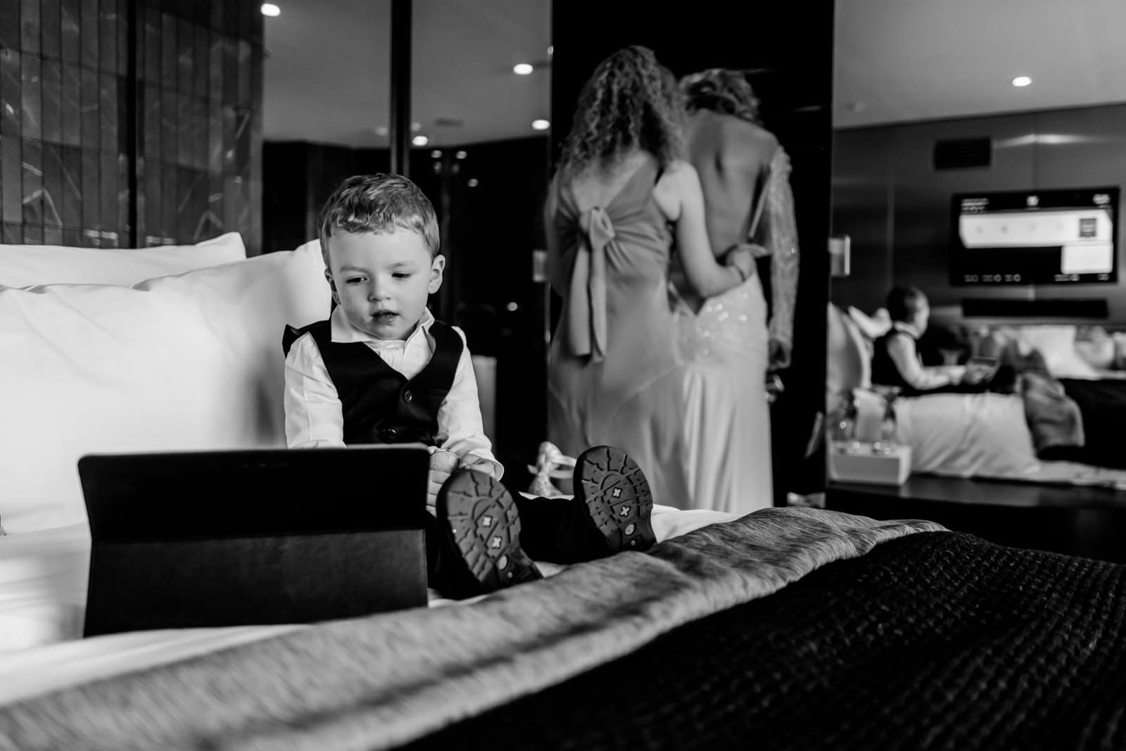 La mariée enfile la robe dans la suite du W Verbier et la petit regarde un film sur son iPad