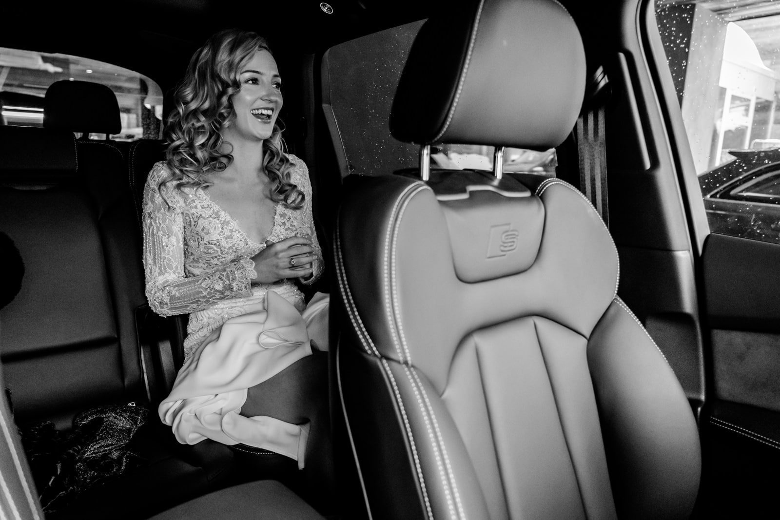 La mariée assise à l'arrière d'une voiture en route vers la cérémonie de mariage à Verbier