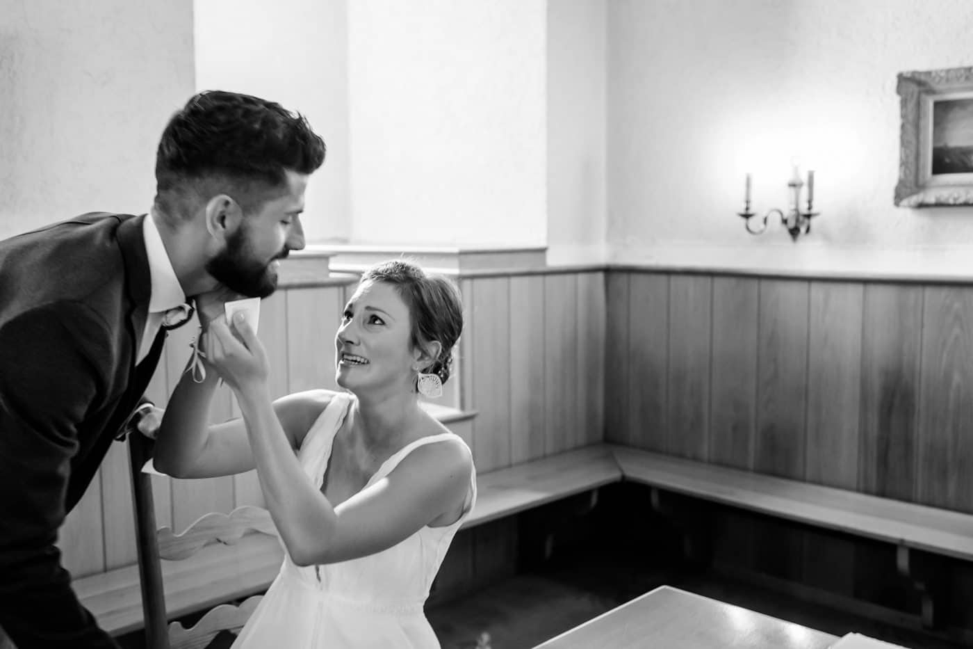 La mariée réajuste la tenue de son époux