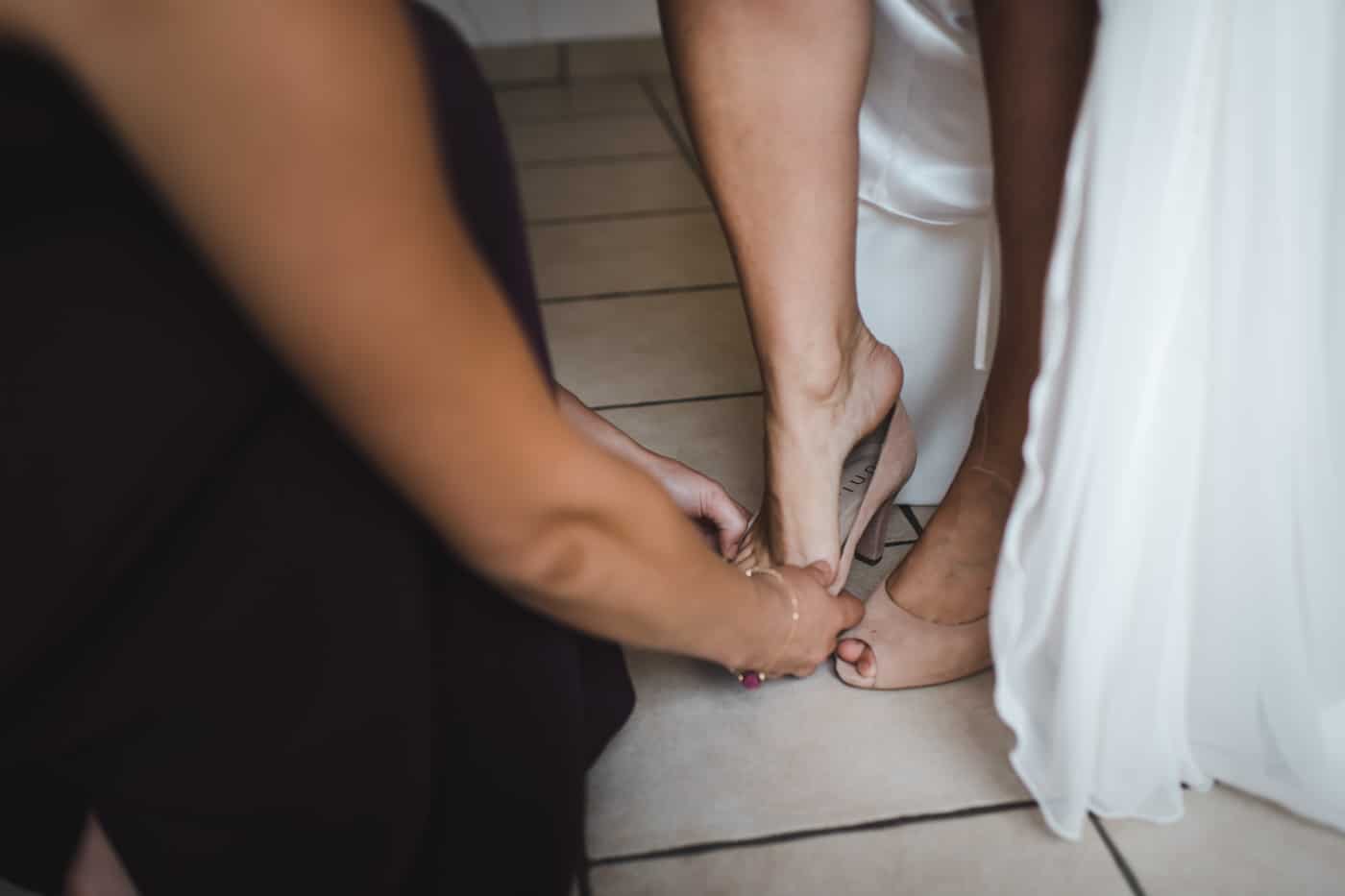 La mariée met les chaussures qui vont l'accompagner durant toute la journée