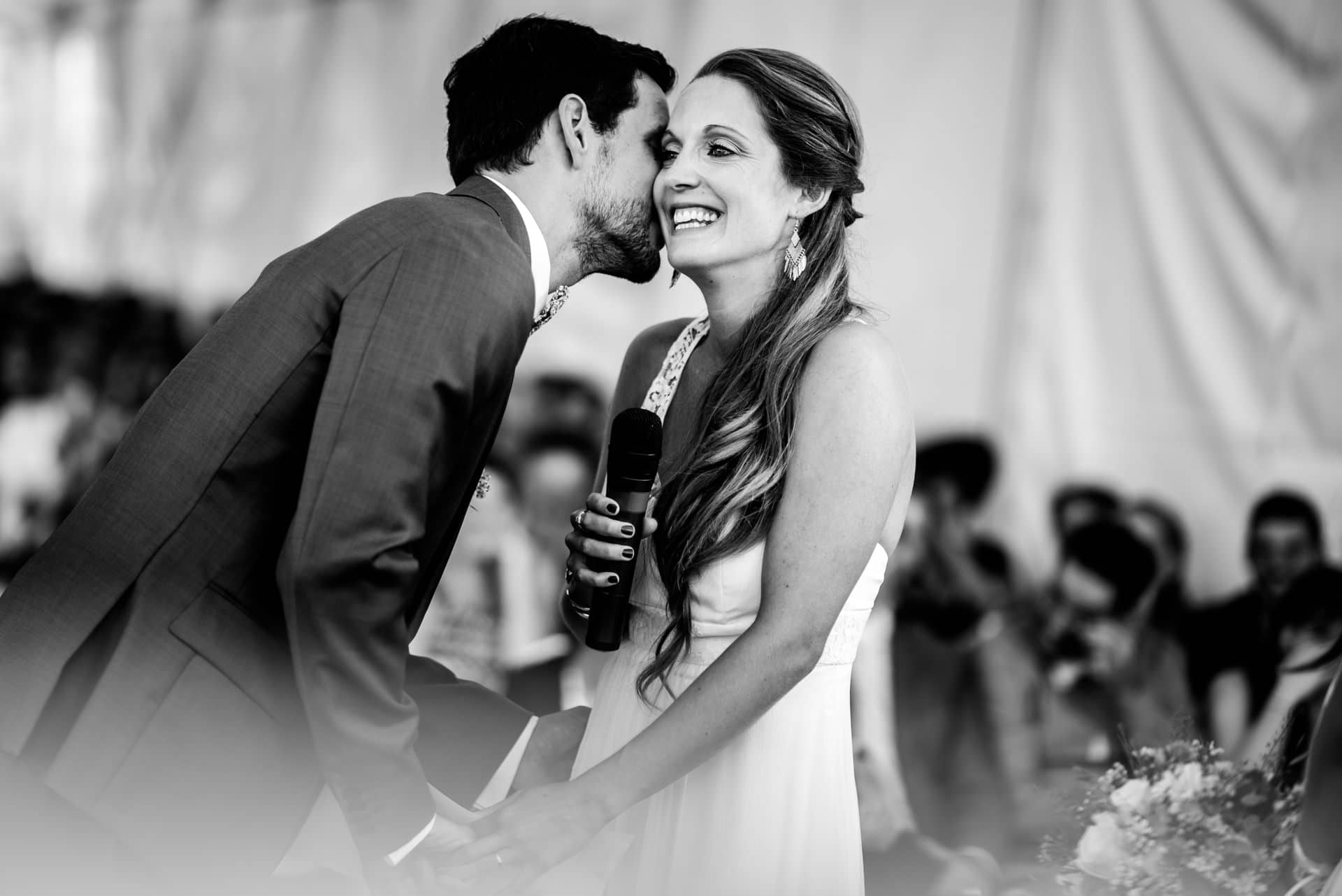 Le marié chuchote à l'oreille de son épouse, tout sourire