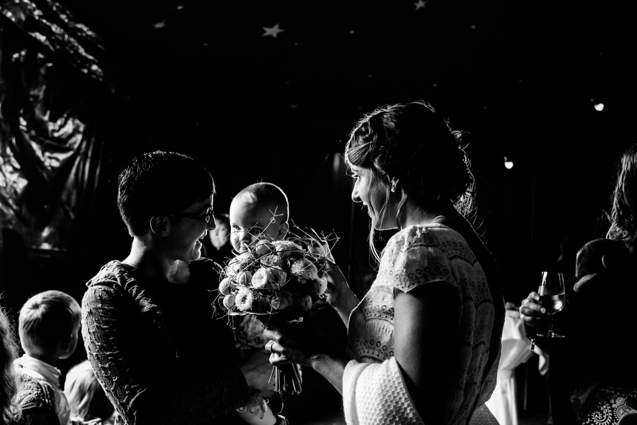 Les mariés dans la pénombre du chapiteau Les mariés dans la pénombre du chapiteau, entourés d'enfants