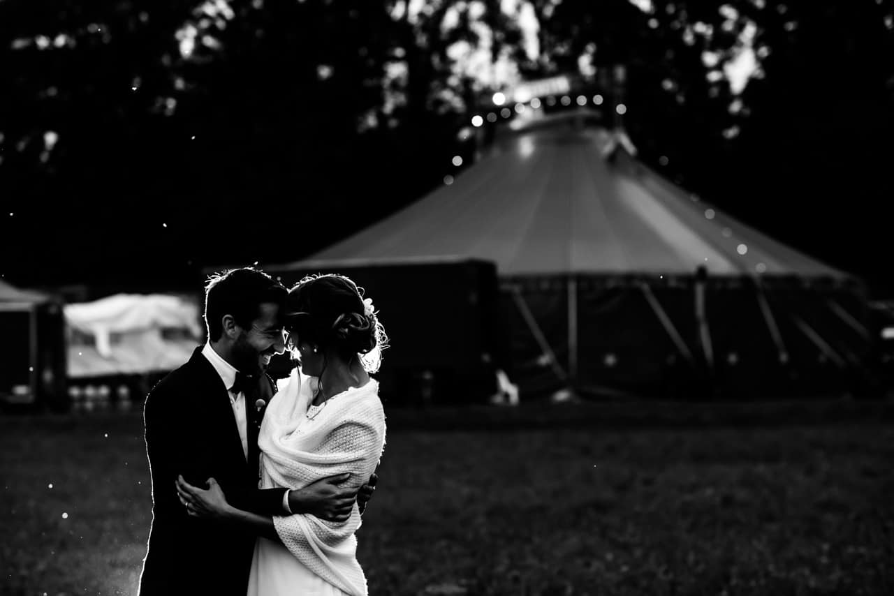Bisou devant le chapiteau Les mariés complices devant le chapiteau