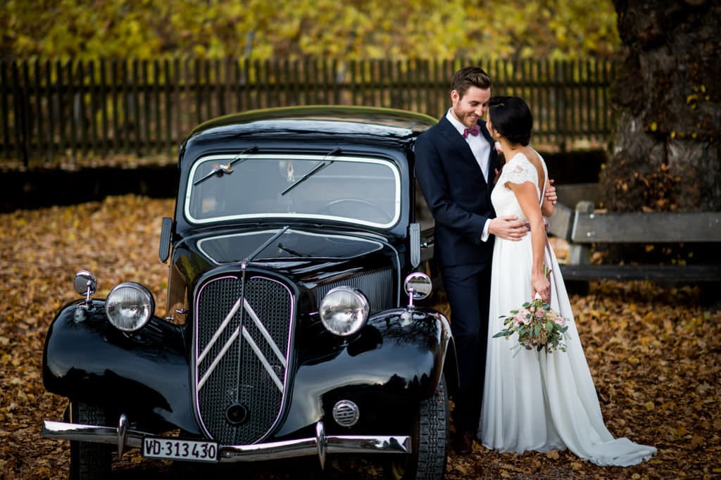 Le couple s'échange un baiser devant l'oldtimer