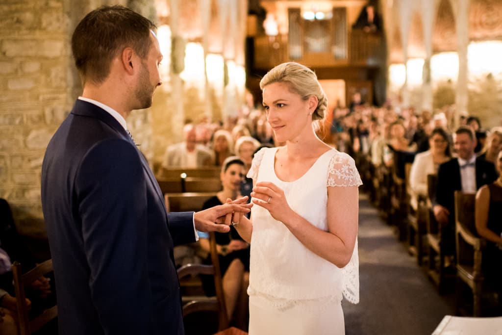 La mariée passe la bague au doigt à son époux