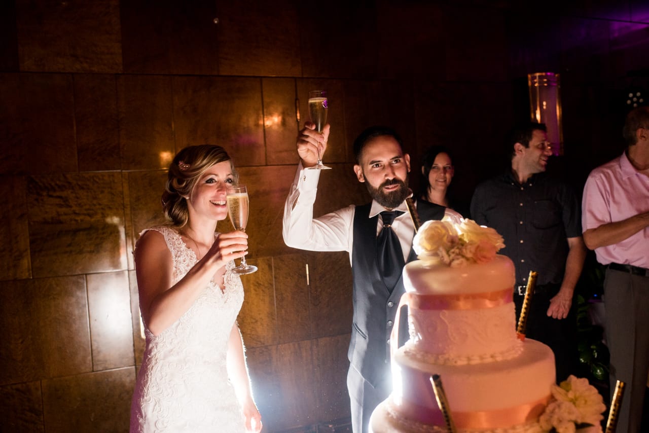 Les mariés trinquent devant la magnifique pièce montée