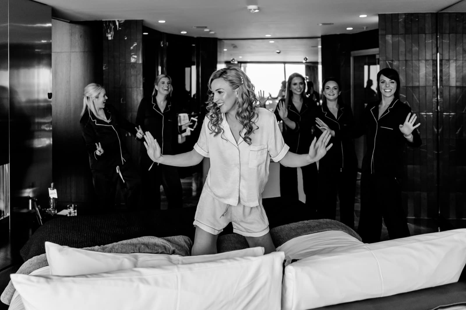 La mariée qui pose avec ses demoiselles d'honneur avant l'enfilage de la robe de mariage
