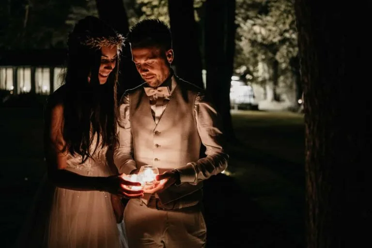 Couple entouré d'obscurité tenant ensemble une petite source lumineuse chaleureuse