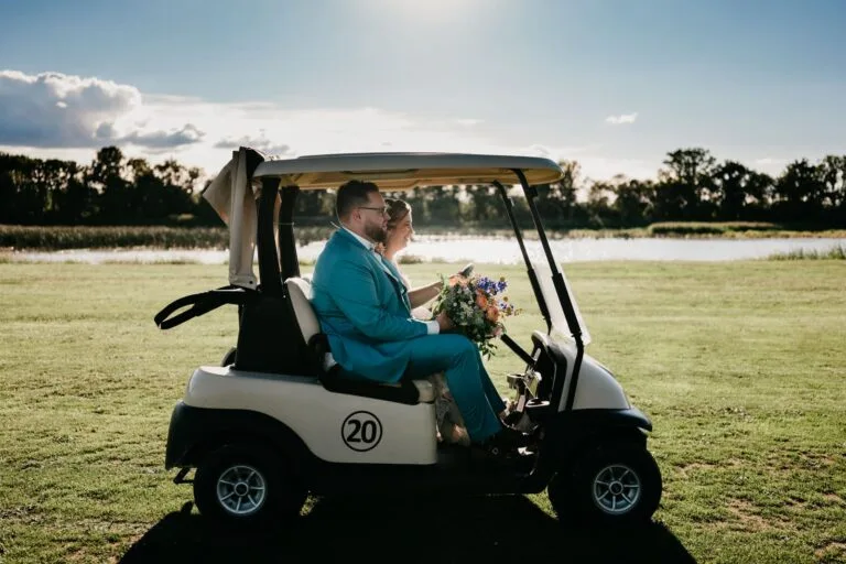 Couple assis dans une voiturette de golf blanche sous un soleil éclatant
