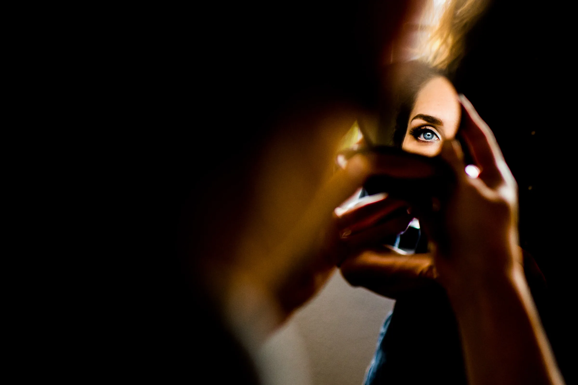 Regard d’une mariée dans un miroir de poche pendant les préparatifs