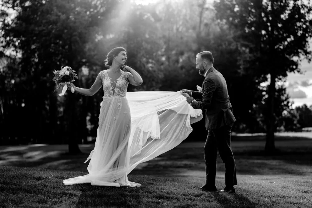 Couple en noir et blanc, l'homme soulève délicatement le voile de la mariée